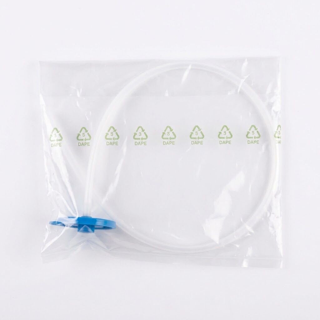 Przezroczysta plastikowa torebka z niebieskim elementem i białym przewodem w środku. Na torebce widoczne są zielone symbole recyklingu z napisem \'DAPE\'.
