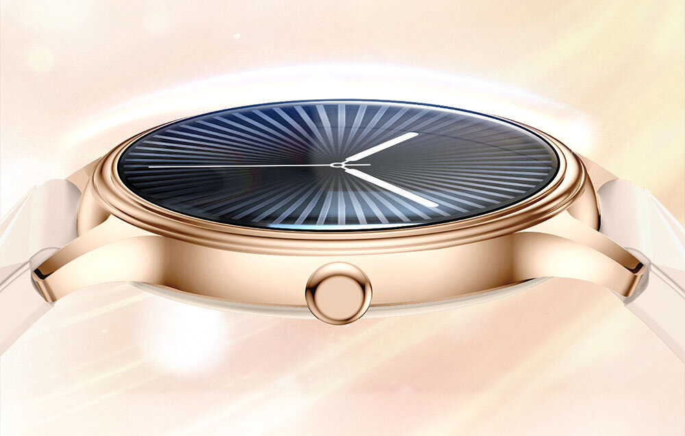 Złoty smartwatch z okrągłą tarczą i wzorem promieniście rozchodzących się linii na ciemnym tle. Pasek jest jasny, a obudowa ma elegancki, metaliczny wygląd.