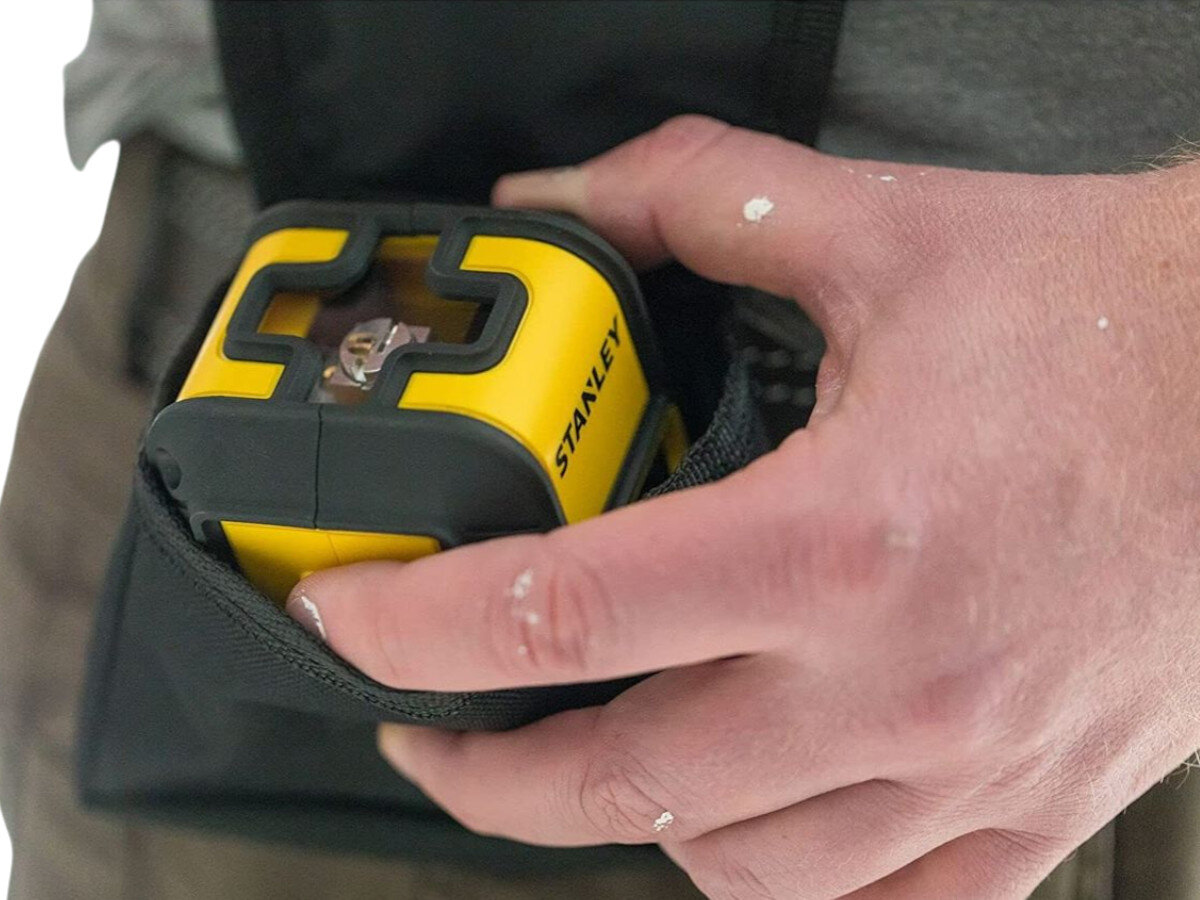 Laser krzyżowy STANLEY Cubix STHT77498-1, transport, auto, blokada, sprzęt, Laser Cubix rzutuje linię na drewnianym blacie.