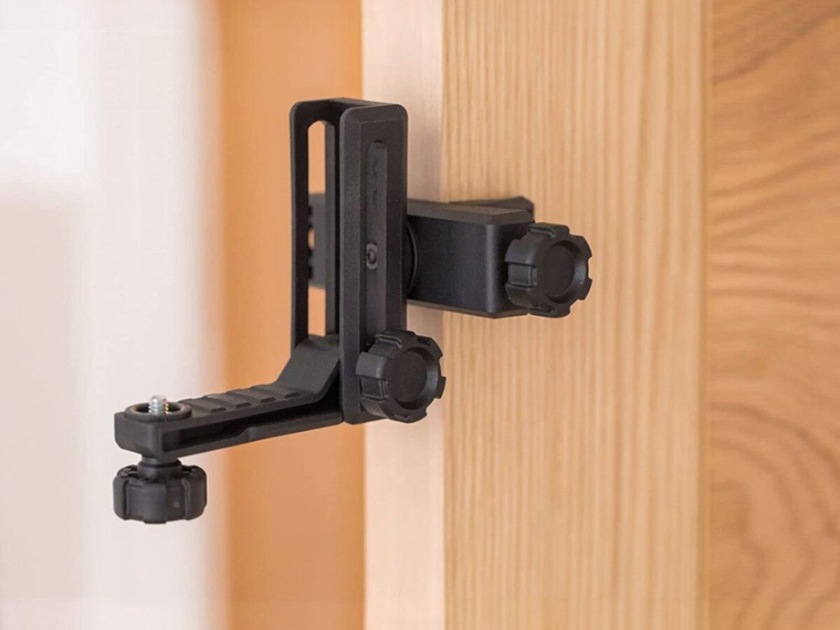 Laser krzyżowy STANLEY Cubix STHT77498-1, bateria, praca, czas, energia, Uchwyt QuickLink zamocowany na drewnianym boku.