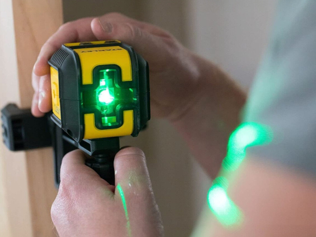 Laser krzyżowy STANLEY Cubix STHT77499-1, pomiar, dystans, wynik, miara, Dłoń trzymająca uchwyt montażowy QuickLink.