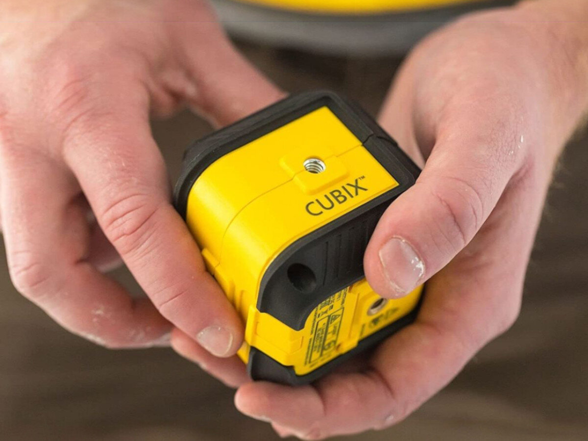 Laser krzyżowy STANLEY Cubix STHT77499-1, transport, auto, blokada, sprzęt, Laser Cubix rzutuje linię na drewnianym blacie.