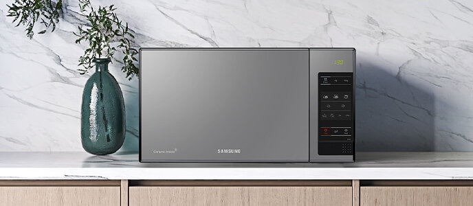Kuchenka mikrofalowa Samsung ME83X-P/EO dostępna w Media Expert Kuchenka mikrofalowa w kolorze czarnym z panelem sterowania po prawej stronie, na którym widoczne są przyciski i wyświetlacz. Na drzwiach znajduje się logo \'SAMSUNG\'.