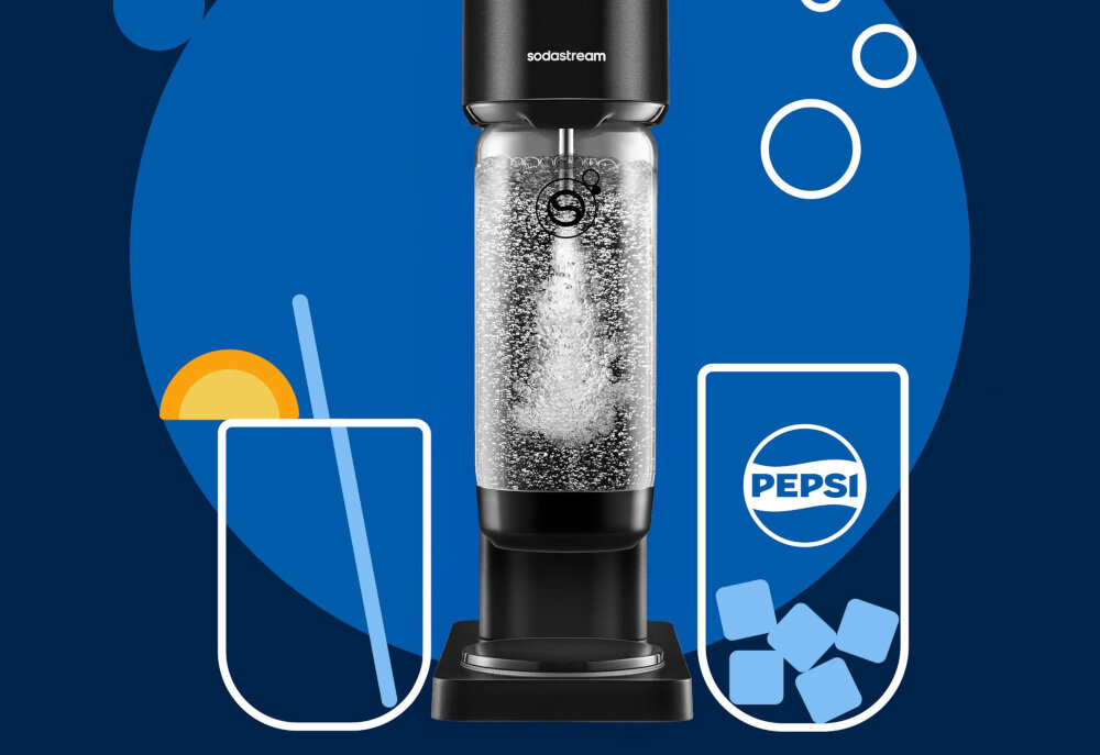 Na obrazie widoczny jest czarny saturator z logo \'sodastream\', wypełniony gazowaną wodą. Obok znajdują się dwa szkice szklanek, jedna z plasterkiem pomarańczy i słomką, druga z logo \'PEPSI\' i kostkami lodu.