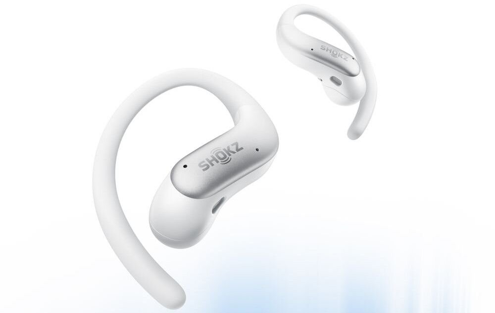 Na obrazie widoczne są białe słuchawki z logo \'SHOKZ\'. Słuchawki mają zakrzywiony kształt, umożliwiający dopasowanie do ucha.