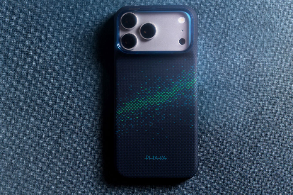 Na obrazie widoczne jest etui na telefon z trzema dużymi otworami na aparaty. Na etui znajduje się wzór przypominający Drogę Mleczną oraz napis \'PITAKA\'.