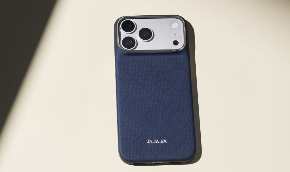 Na zdjęciu widoczne jest niebieskie etui na telefon z trzema dużymi obiektywami aparatu. Na etui znajduje się napis \'PITAKA\'.