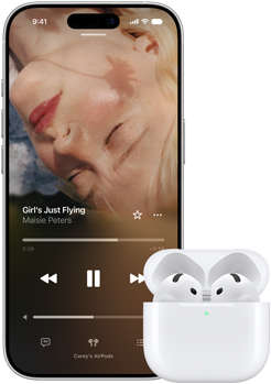 Na obrazie widoczny jest smartfon z odtwarzaczem muzyki, na którym wyświetlana jest piosenka \'Girl\'s Just Flying\' Maisie Peters oraz białe słuchawki douszne w etui ładującym.