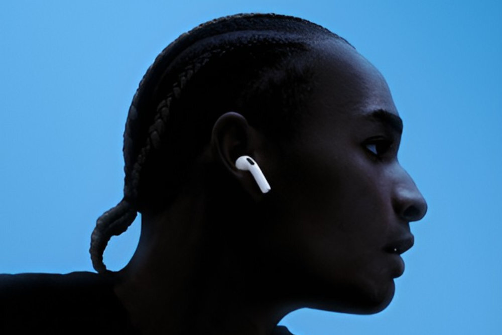 Apple AirPods 5 współdzielenia dźwięku dwie pary AirPods z iPhonem, iPadem lub Apple TV zbliżenie AirPods do urządzenia odtwarzającego - Ciemna sylwetka profilu twarzy z założoną słuchawką douszną
