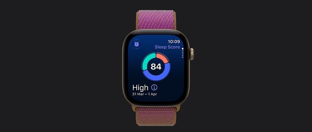 Smartwatch z kolorowym wyświetlaczem pokazuje wynik snu 84 oraz daty 31 Mar - 1 Apr. Pasek jest w kolorze granatowym z różowymi akcentami.