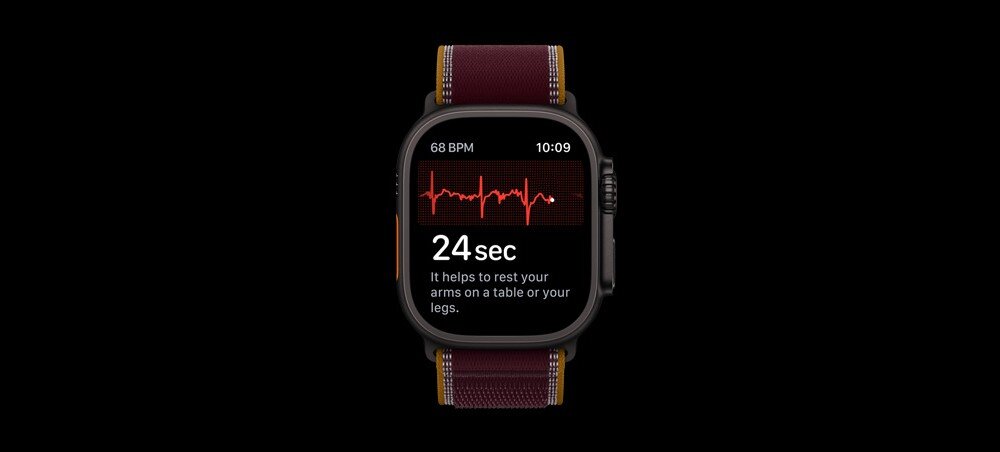 Zegarek z wyświetlaczem pokazującym wykres tętna, wartość 68 BPM i czas 10:09. Tekst na ekranie: \'24 sec It helps to rest your arms on a table or your legs.\'