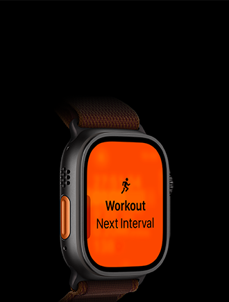Smartwatch z czarną kopertą i bransoletą, wyświetlający pomarańczowy ekran z ikoną biegnącej osoby oraz tekstem \'Workout Next Interval\'.