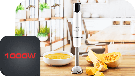 Na blacie kuchennym stoi blender ręczny z logo Tefal, obok miska z zupą i pokrojona dynia. W rogu widoczny jest napis \'1000W\'.