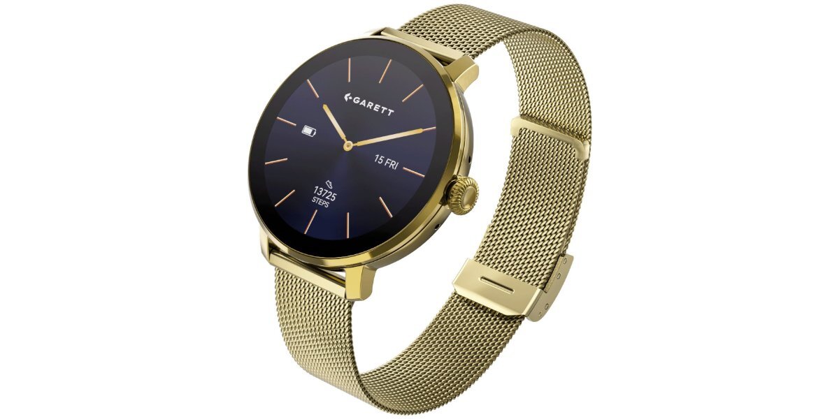 Złoty smartwatch z okrągłą tarczą, na której widoczne są wskazówki, logo \'GARETT\', data \'15 FR\', oraz liczba \'13125\'. Pasek zegarka jest wykonany z metalowej siatki.