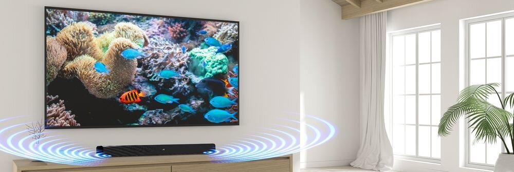 W salonie na szafce stoi czarny soundbar, przed dużym telewizorem wyświetlającym obraz rafy koralowej z rybami. Wokół soundbara widoczne są niebieskie fale dźwiękowe.