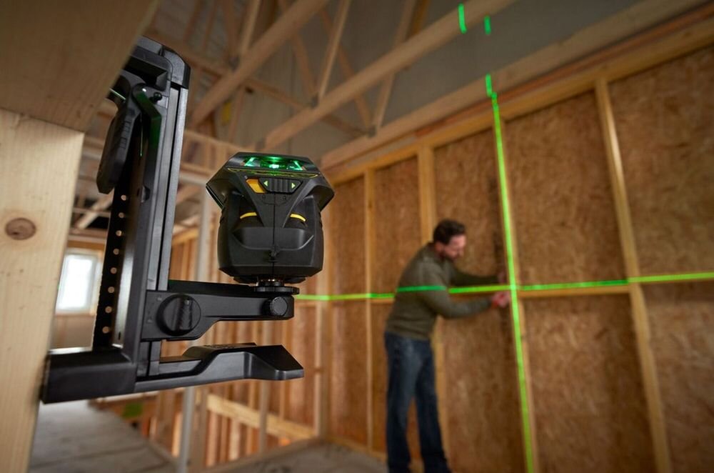 Laser krzyżowy STANLEY FatMax Multi-Line Laser 360, poziom, zasięg, pełen, 360, mężczyzna pracuje przy liniach odmierzonych dzięki laserowi na statywie