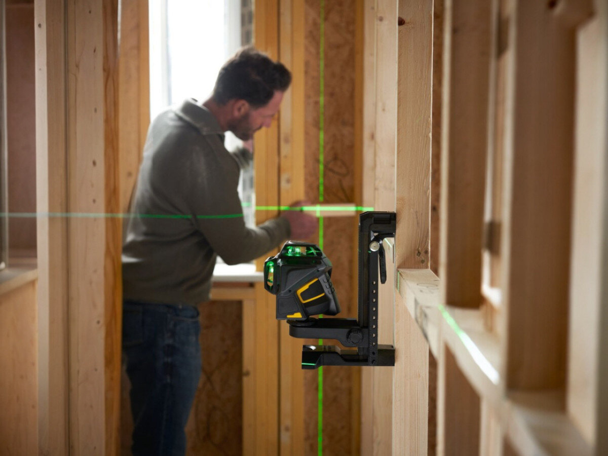 Laser krzyżowy STANLEY FatMax Multi-Line Laser 360, wahadło, poziom, transport, ochrona, mężczyzna pracuje przy ścianie z włączonym laserem