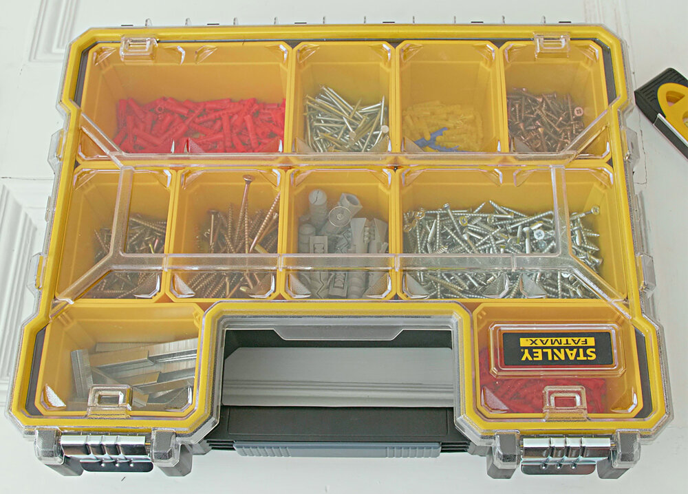 Organizer STANLEY 1-97-518 zamknięty organizer na białym blacie pojemniki wypełnione akcesoriami do bezpiecznego przechowywania i transportu drobnych elementów wodoodporna uszczelka solidne materiały ochrona przed kurzem wilgocią i przypadkowymi uszkodzeniami