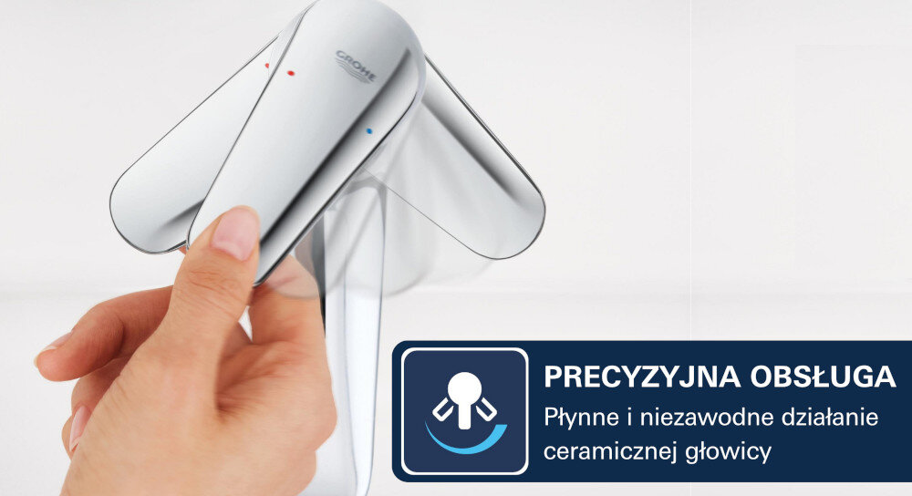Osoba reguluje uchwyt chromowanej baterii umywalkowej z widocznym logo GROHE. Obok znajduje się grafika z tekstem: \'PRECYZYJNA OBSŁUGA Płynne i niezawodne działanie ceramicznej głowicy\'.