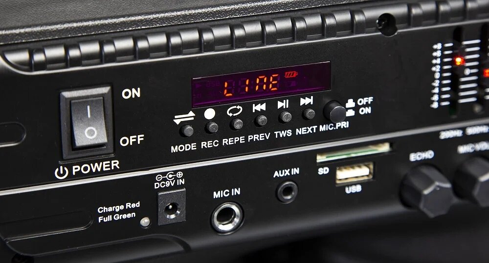 Panel sterowania urządzenia audio z wyświetlaczem pokazującym \'LINE\'. Widoczne są przyciski do zmiany trybów, wejścia AUX IN, MIC IN, SD, USB oraz pokrętła do regulacji dźwięku.