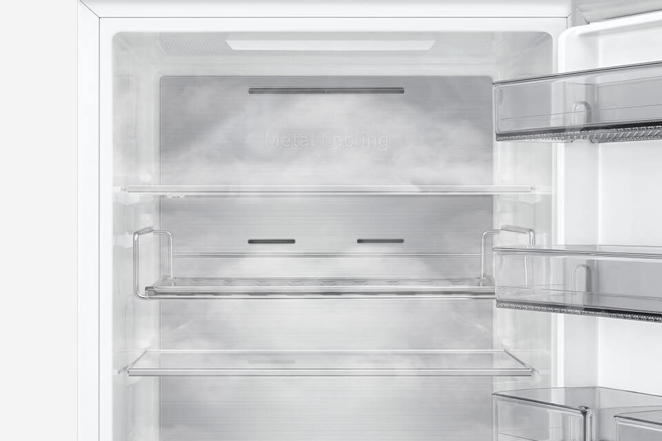 Wnętrze lodówki z widocznymi półkami i szufladami. Na tylnej ściance znajduje się napis \'Metal Cooling\'.