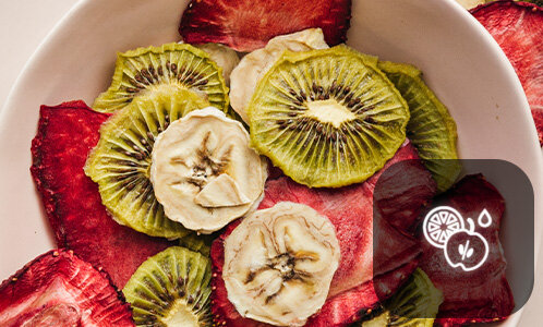Na obrazie widoczny jest talerz z suszonymi plasterkami kiwi, bananów i truskawek. W prawym dolnym rogu znajduje się ikona przedstawiająca owoce i kroplę wody.