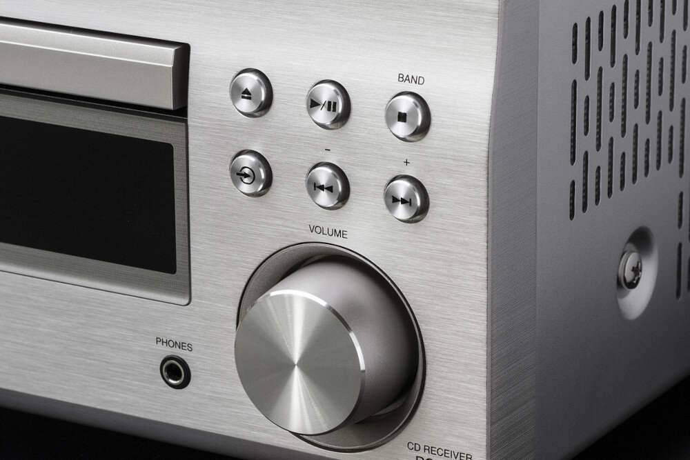 Zbliżenie na panel przedni amplitunera stereo z przyciskami funkcyjnymi i pokrętłem głośności. Widoczne napisy to: BAND, VOLUME, PHONES, CD RECEIVER.