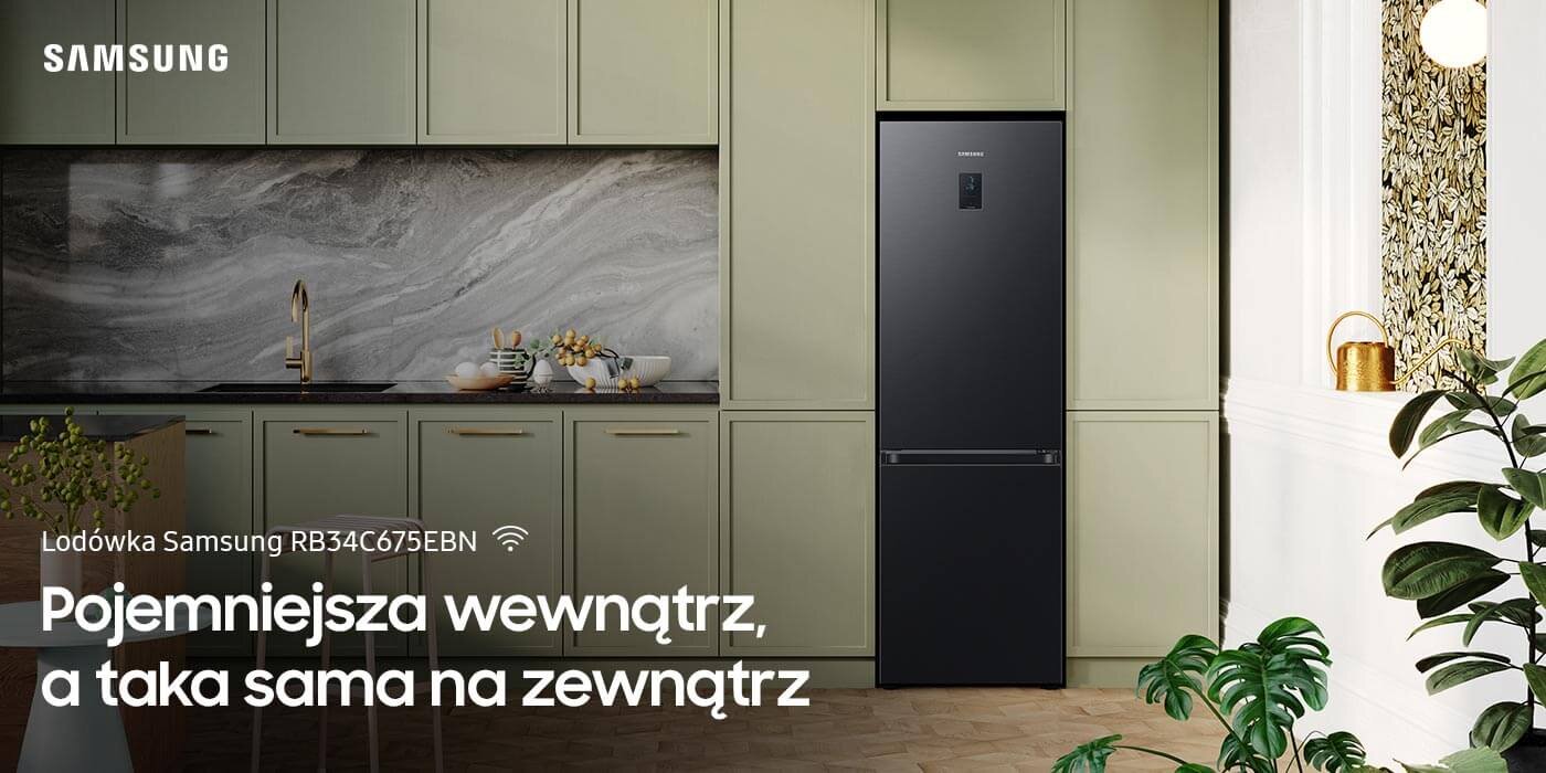 Lodówka Samsung Grand+ RB34C675EBN z zewnętrznym panelem sterowania Czarna lodówka Samsung RB34C675EBN stoi w eleganckiej kuchni z zielonymi szafkami i marmurowym blatem. Na obrazie widoczny jest tekst: \'Lodówka Samsung RB34C675EBN Pojemniejsza wewnątrz, a taka sama na zewnątrz\'.