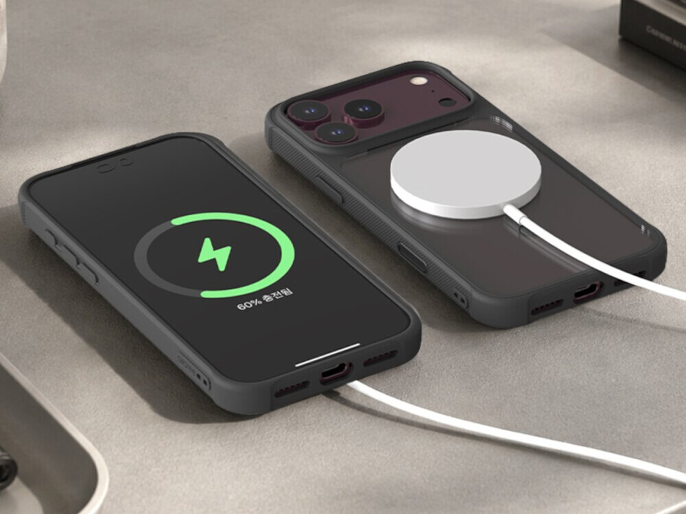 Na obrazie widoczne są dwa smartfony w etui, jeden z ekranem pokazującym ikonę ładowania i napis \'60% 충전됨\', drugi z podłączoną ładowarką MagSafe. Oba urządzenia leżą na jasnej powierzchni.