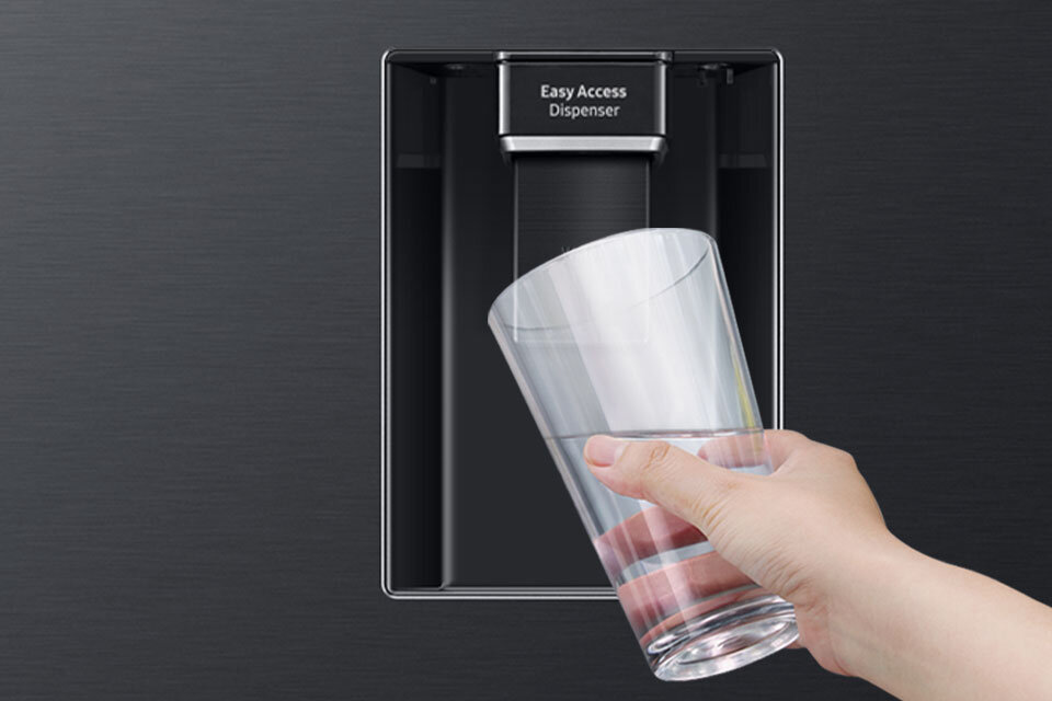 Dystrybutor wody bez bisfenolu A - lodówka RB34C652EBN Osoba trzyma szklankę pod podajnikiem wody z napisem \'Easy Access Dispenser\'.