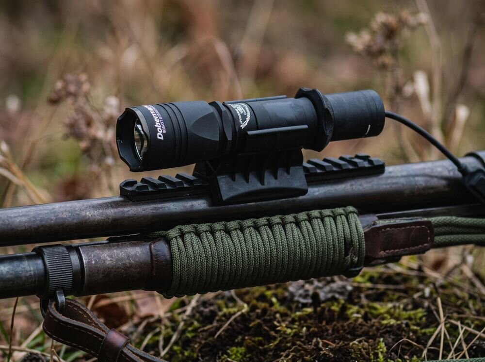 Latarka taktyczna ARMYTEK F02005W, pokrowiec, klips, smycz, uchwyt, Latarka zamontowana na szynie nad lufą broni.