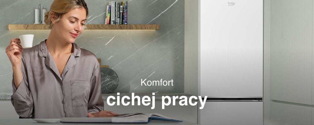 Kobieta w szarej koszuli trzyma filiżankę, siedząc przy stole z otwartą książką. Obok niej znajduje się lodówka z logo \'beko\' oraz tekst \'Komfort cichej pracy\'.
