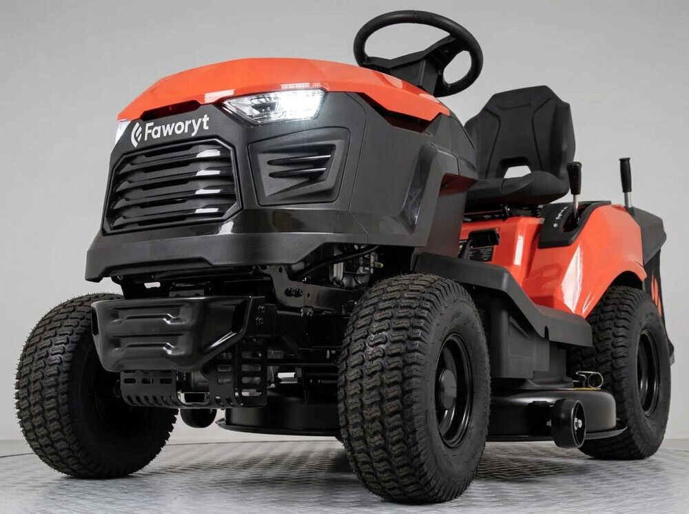 Traktor ogrodowy FAWORYT DT98 HV2, fotel, oświetlenie, zderzak, bezpieczeństwo, Uśmiechnięty mężczyzna jadący kosiarką samojezdną w otoczeniu kwitnących krzewów.
