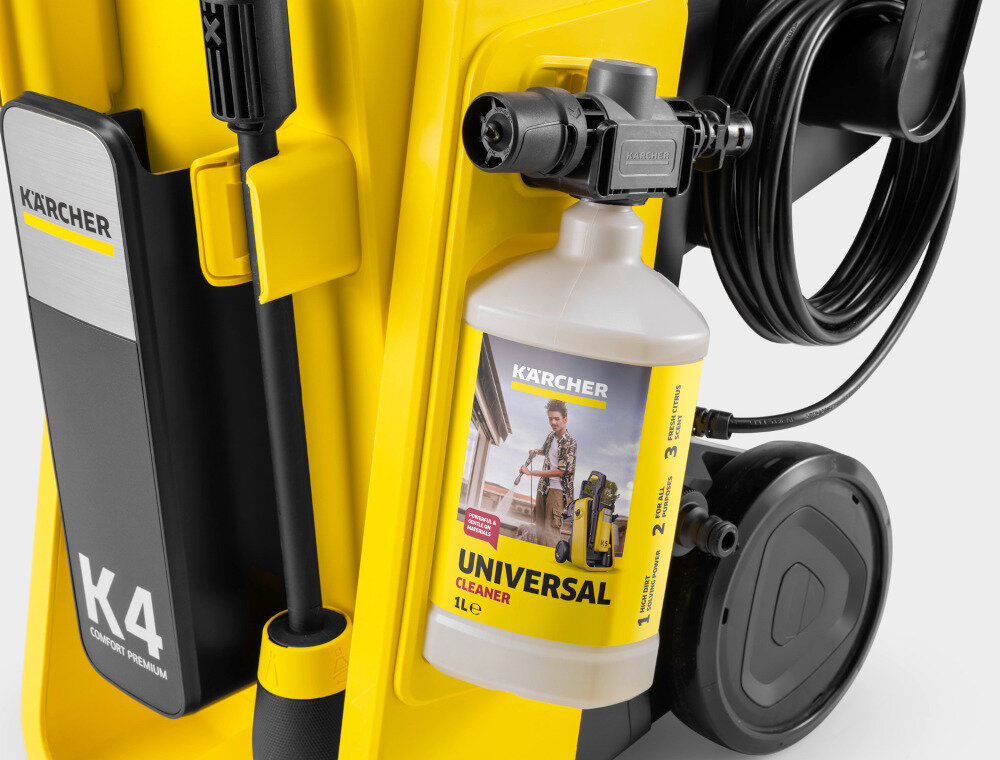 Zdjęcie przedstawia żółtą myjkę ciśnieniową z widocznym logo KARCHER oraz butelką środka czyszczącego o nazwie \'UNIVERSAL CLEANER 1L\'.