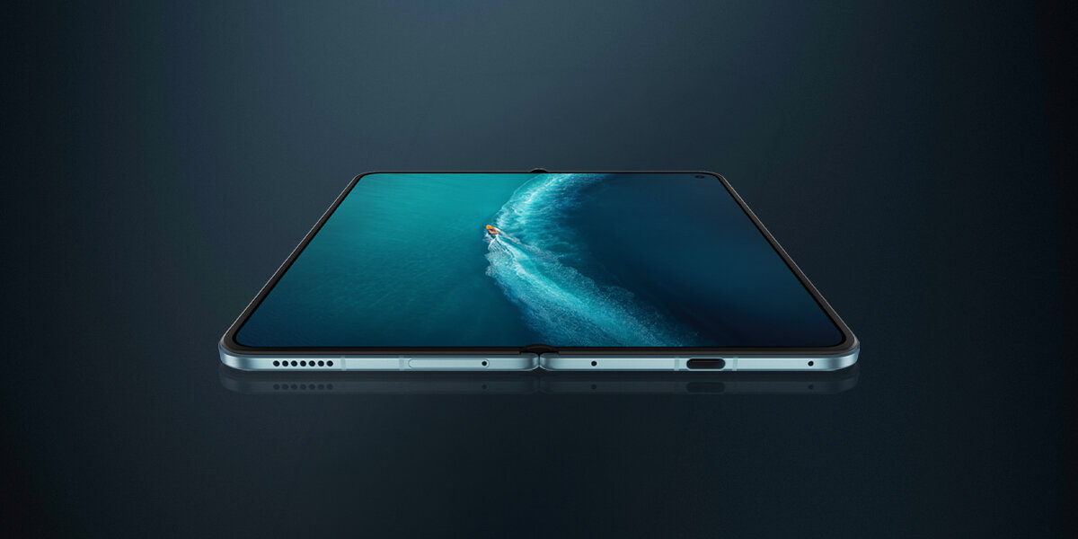 Składany smartfon vivo X Fold6 pokazany po rozłożeniu. Duży ekran zajmuje niemal całą wewnętrzną powierzchnię urządzenia i wyświetla zdjęcie oceanu, a smukła konstrukcja telefonu jest widoczna z niskiej perspektywy.