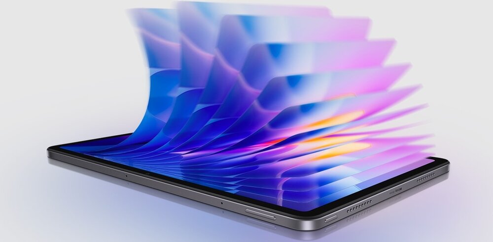 Obraz przedstawia tablet z efektem wizualnym, gdzie z ekranu wydobywają się kolorowe, półprzezroczyste warstwy w odcieniach niebieskiego i fioletowego. Tablet ma metaliczną obudowę i widoczne przyciski oraz głośniki na krawędzi.
