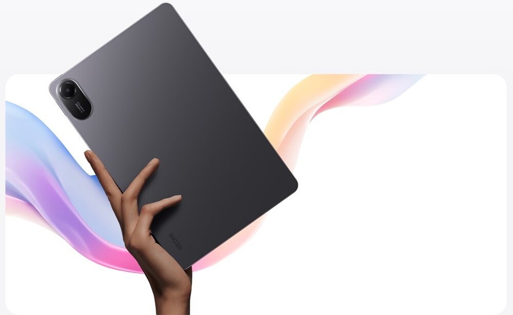 Osoba trzyma szary tablet z widocznym aparatem w rogu. W tle widać kolorowe, falujące linie.