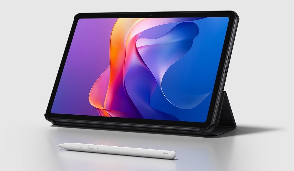 Tablet w etui z wyświetlaczem prezentującym kolorową grafikę, obok leży biały rysik. Na rysiku widoczny jest napis \'Xiaomi\'.