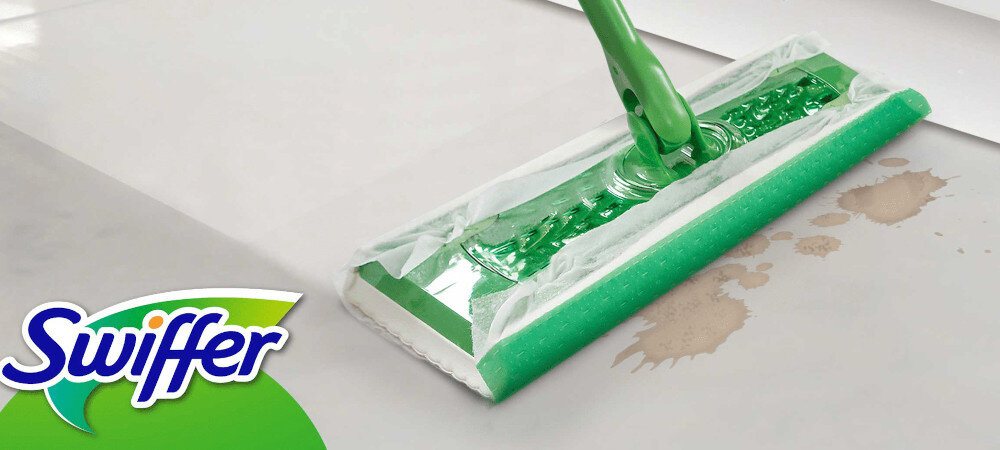 Na obrazie widoczny jest zielony mop płaski z białą nakładką, który usuwa zabrudzenia z podłogi. W lewym dolnym rogu znajduje się logo \'Swiffer\'.