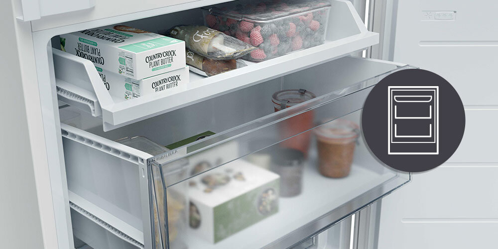 Wnętrze lodówki z widocznymi półkami, na których znajdują się produkty spożywcze, takie jak masło roślinne i owoce. Obok lodówki znajduje się ikona przedstawiająca schemat szuflad.