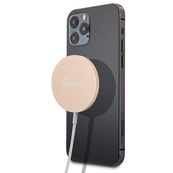 Na obrazie widoczny jest smartfon z przymocowaną ładowarką indukcyjną w kolorze złotym z napisem \'Guess\'. Ładowarka jest podłączona kablem.