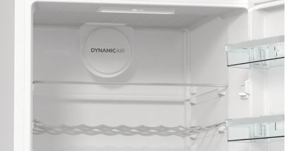 Wnętrze białej lodówki z widocznymi półkami i napisem \'DYNAMICAIR\'.