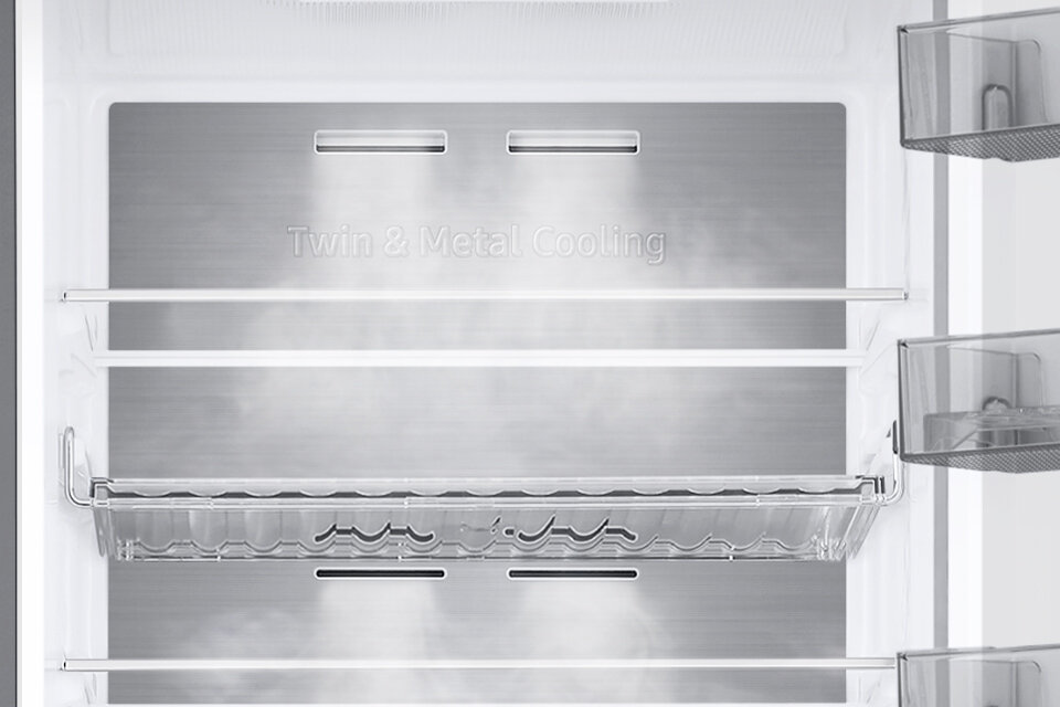 metalowe wykończenie tylnej ścianki lodówki Wnętrze lodówki z metalowym panelem z napisem \'Twin & Metal Cooling\', wyposażone w półki i przezroczyste pojemniki na drzwiach.