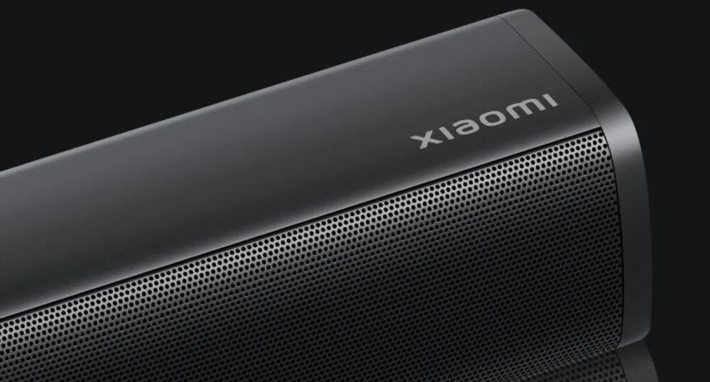 Czarny soundbar z widocznym logo \'xiaomi\' na górnej powierzchni. Przód urządzenia pokryty jest perforowaną siatką.