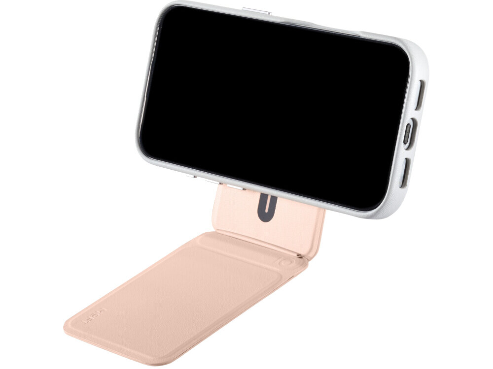 Na obrazie widoczny jest telefon w białej obudowie, zamocowany na brzoskwiniowym magnetycznym portfelu i stojaku. Produkt ma minimalistyczny design z widocznym logo \'MOFT\'.