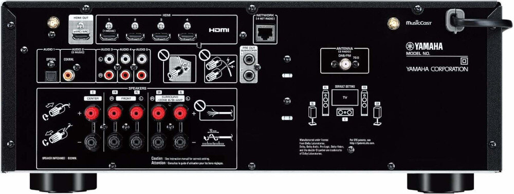 Tył urządzenia audio z różnymi portami i złączami, w tym HDMI, optycznym, sieciowym oraz głośnikowymi. Widoczne są oznaczenia i instrukcje dotyczące podłączenia, a także logo YAMAHA i YAMAHA CORPORATION.