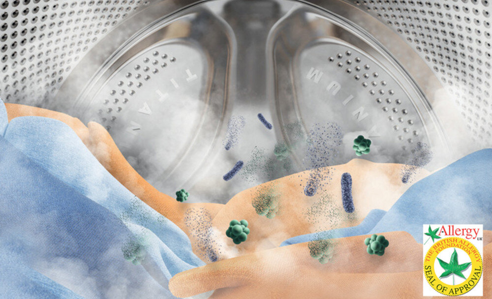 Wnętrze bębna pralki z widoczną parą i tkaniną, na której znajdują się ilustracje bakterii. W prawym dolnym rogu znajduje się logo z napisem \'Allergy UK Seal of Approval\'.
