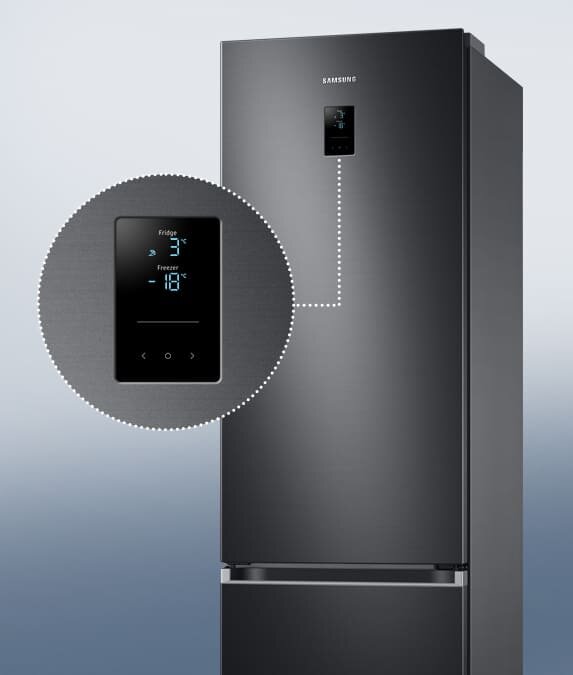 Zbliżenie na zewnętrzny wyświetlacz w lodówce RB38C776CB1 Grafitowa lodówka z wyświetlaczem pokazującym temperatury: Fridge 3°C, Freezer -18°C. Na lodówce widoczne jest logo \'SAMSUNG\'.