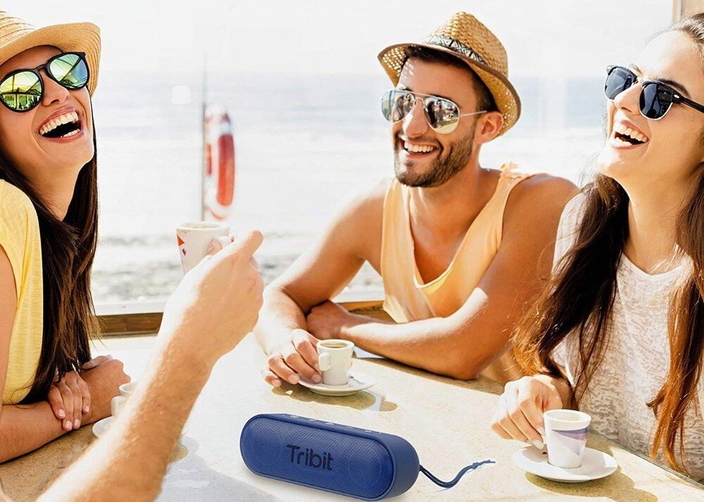 Głośnik mobilny TRIBIT XSound Go BTS58, akumulator 4000 mAh, 24 godziny pracy, ładowanie USB-C, osoby imprezujące na plaży, głośnik stojący na stole