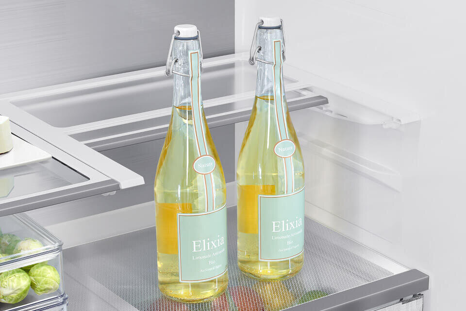 rm90f67cecef składana półka W lodówce znajdują się dwie butelki z napisem \'Elixia Limonade Bio\'. W tle widoczne są półki i pojemniki na żywność.
